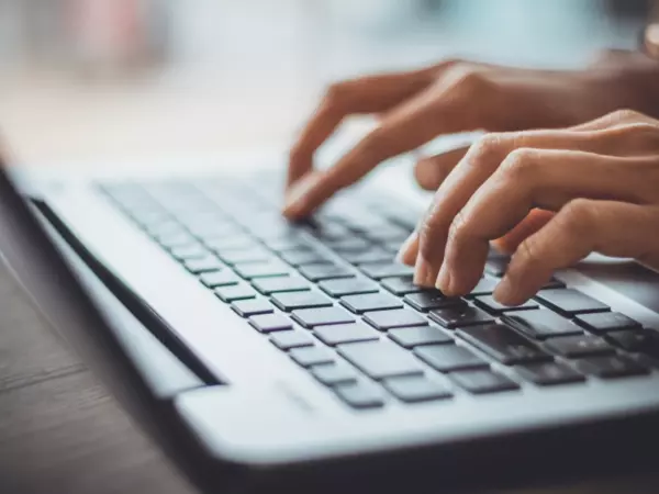 Hände auf einer Laptop-Tastatur